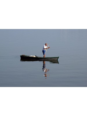 Pescador com sua Canoa em aguas plácidas São Vicente - SP.